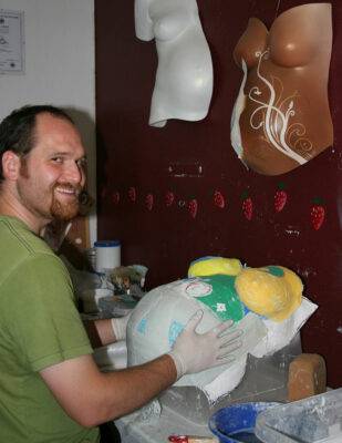 Oli bei der Bearbeitung eines Abdruckes von Brust und Babybauch.