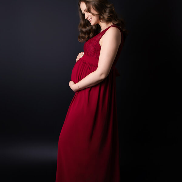 Schwangere beim Mini-Shooting mit rotem Kleid und schwarzem Hintergrund Karlsruhe