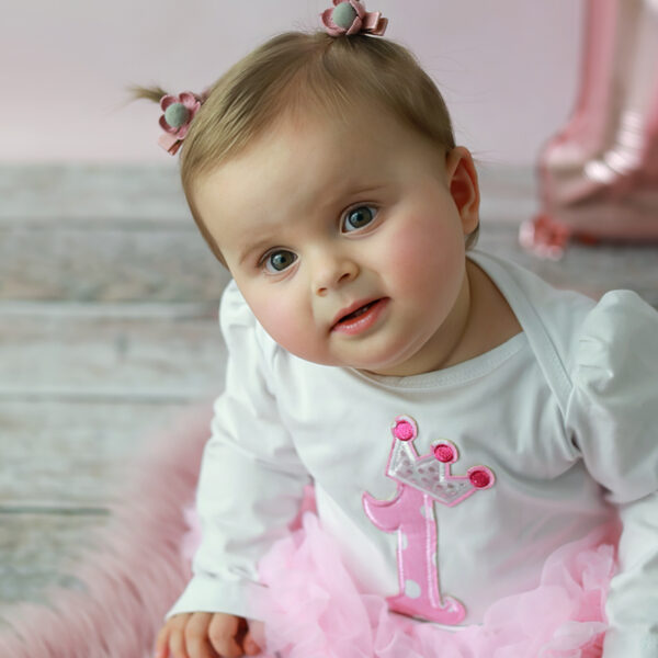 Fotoshooting zum ersten Geburtstag: Mädchen mit Geburtstagsoutfit und Ballon-Eins