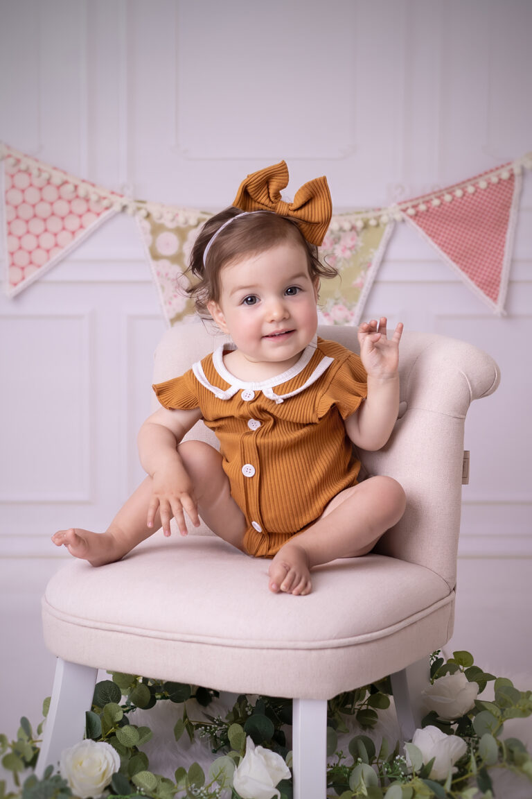 Kind sitzt entspannt auf einem kleinen Sessel im Fotostudio in Karlsruhe, natürliche Pose und ruhiger Blick.