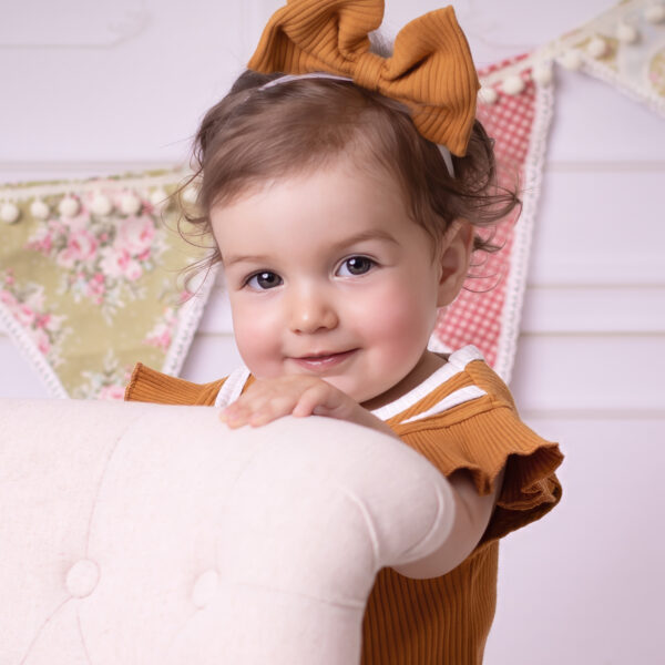 Kinderfotografie im Fotostudio Karlsruhe in einem hellen, ruhigen Set mit zarten Details im Hintergrund.