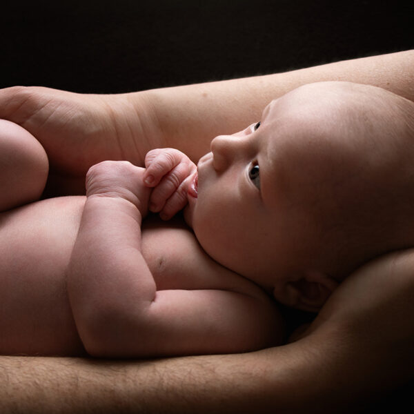Newborn Shooting in Karlsruhe - Baby liegt in den Armen der Eltern