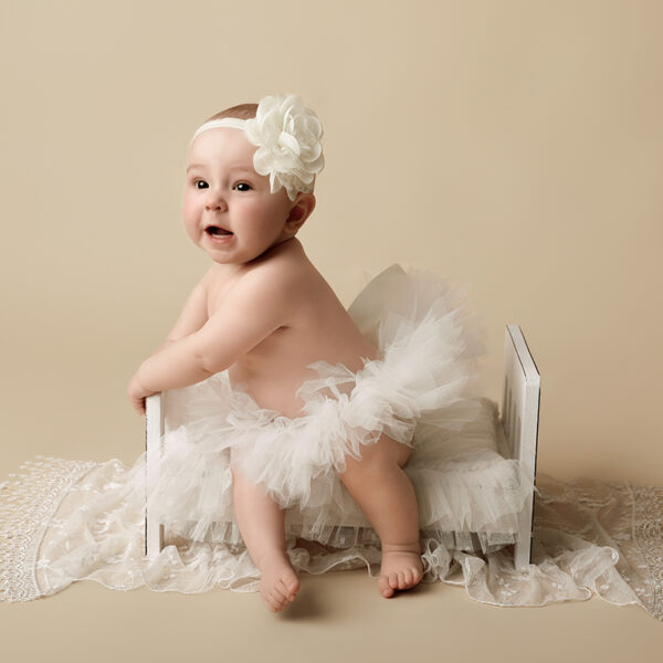 Baby sitzt im kleinen Bettchen im Fotostudio, Sitter Shooting Karlsruhe.