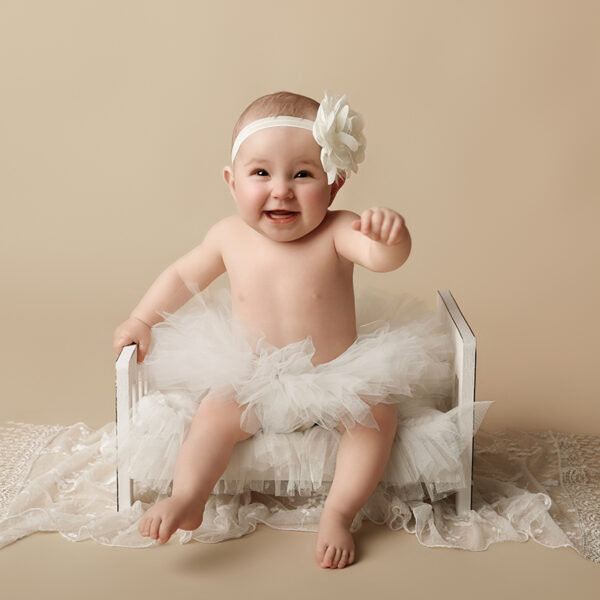 Baby sitzt im Fotostudio und lächelt in die Kamera, Sitter Shooting in Karlsruhe.