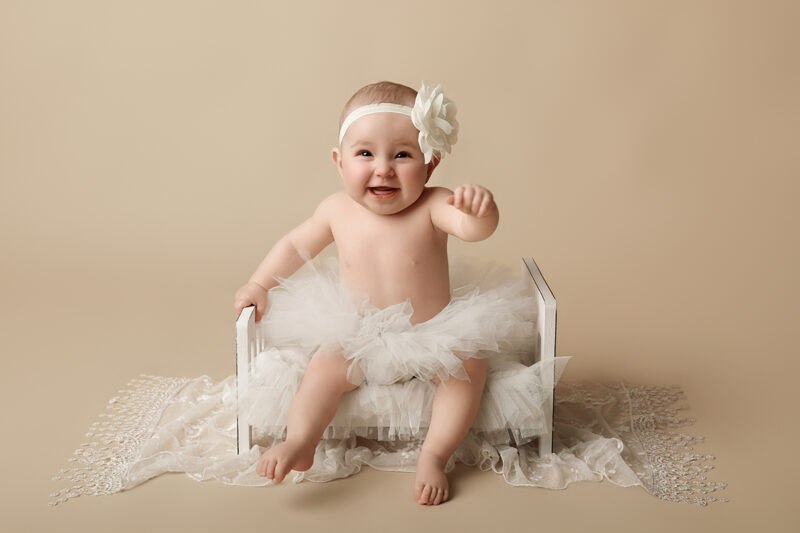 Baby sitzt im Fotostudio und lächelt in die Kamera, Sitter Shooting in Karlsruhe.