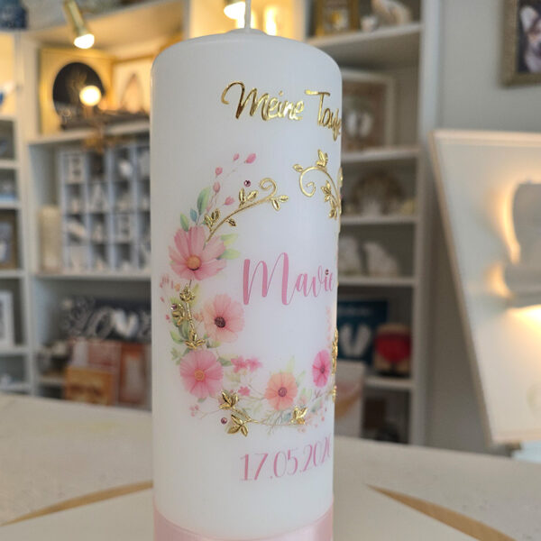 Personalisierte Taufkerze mit Blumenkranz, goldenen Verzierungen und Name sowie Taufdatum auf der Vorderseite.