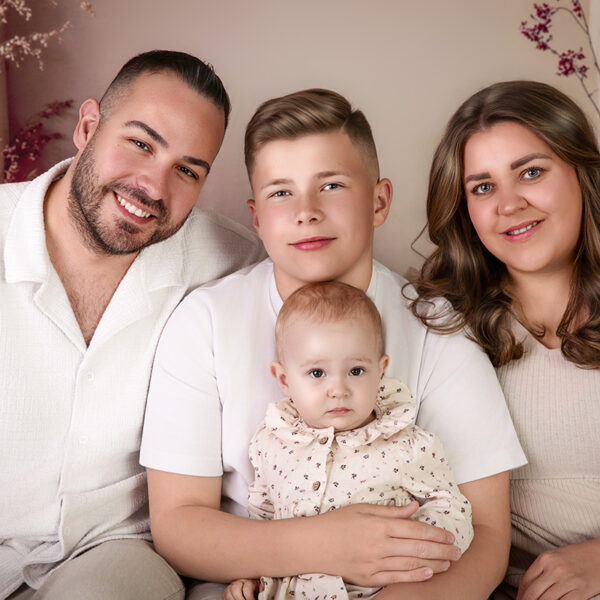 Familienfoto mit Eltern, jugendlichem Sohn und kleiner Tochter auf dem Sofa im Atelier in Karlsruhe