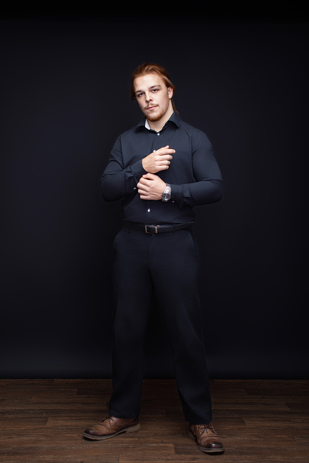 Präsent stehendes Businessporträt eines Mannes beim Richten der Manschetten im Fotostudio Karlsruhe