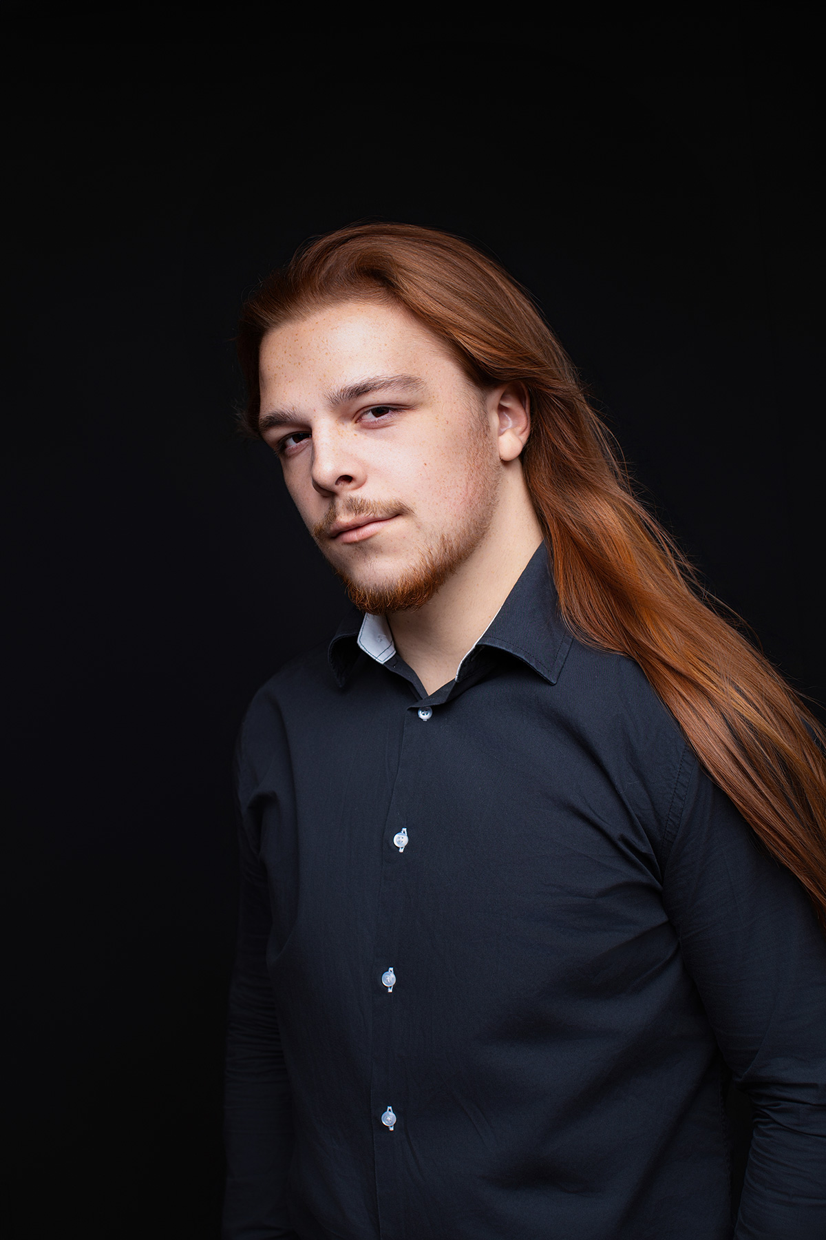Ausdrucksstarkes Porträt eines Mannes mit offenen Haaren im Halbprofil beim Signature Fotoshooting in Karlsruhe
