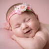 Lächelndes Neugeborenes mit Blumen-Haarband beim Deluxe Baby-Fotoshooting im Fotostudio Atelier Stolzenburg Karlsruhe