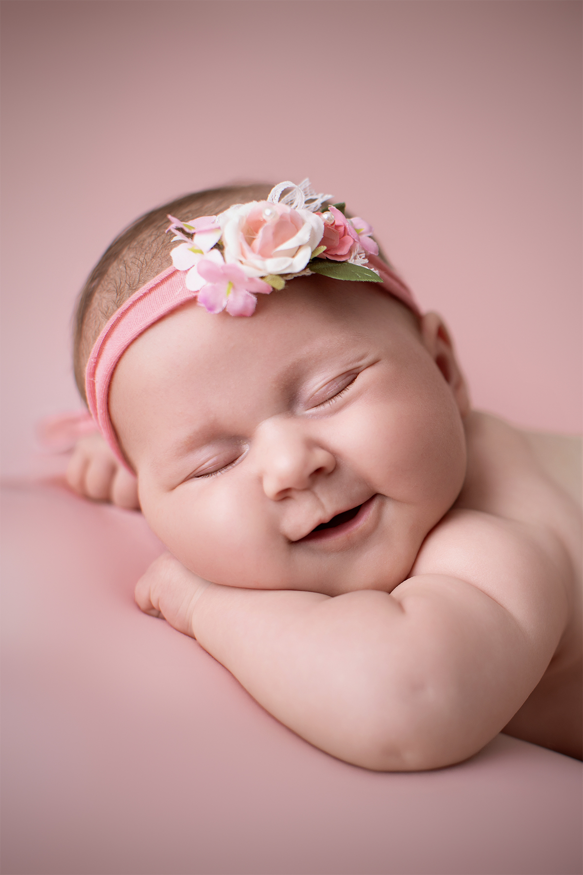 Lächelndes Neugeborenes mit Blumen-Haarband beim Deluxe Baby-Fotoshooting im Fotostudio Atelier Stolzenburg Karlsruhe